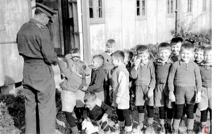 Pahiatua, NZ: The camp commandant, Major Foxley, shows the kindergarteners a "disappearing sixpence" trick. PHOTO courtesy of the Kresy-Siberia Virtual MuseumExhibition: Daily Life 