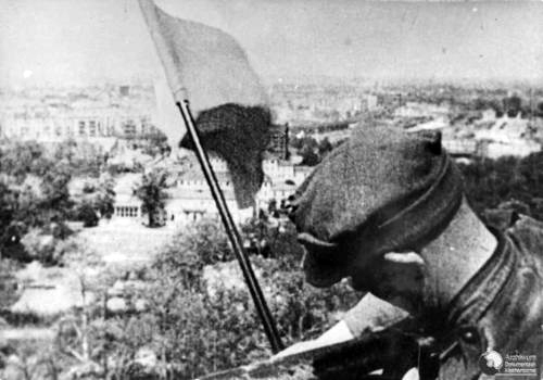 May 1945: Polish soldier Mikołaj Troicki arranges the Polish flag in Berlin.